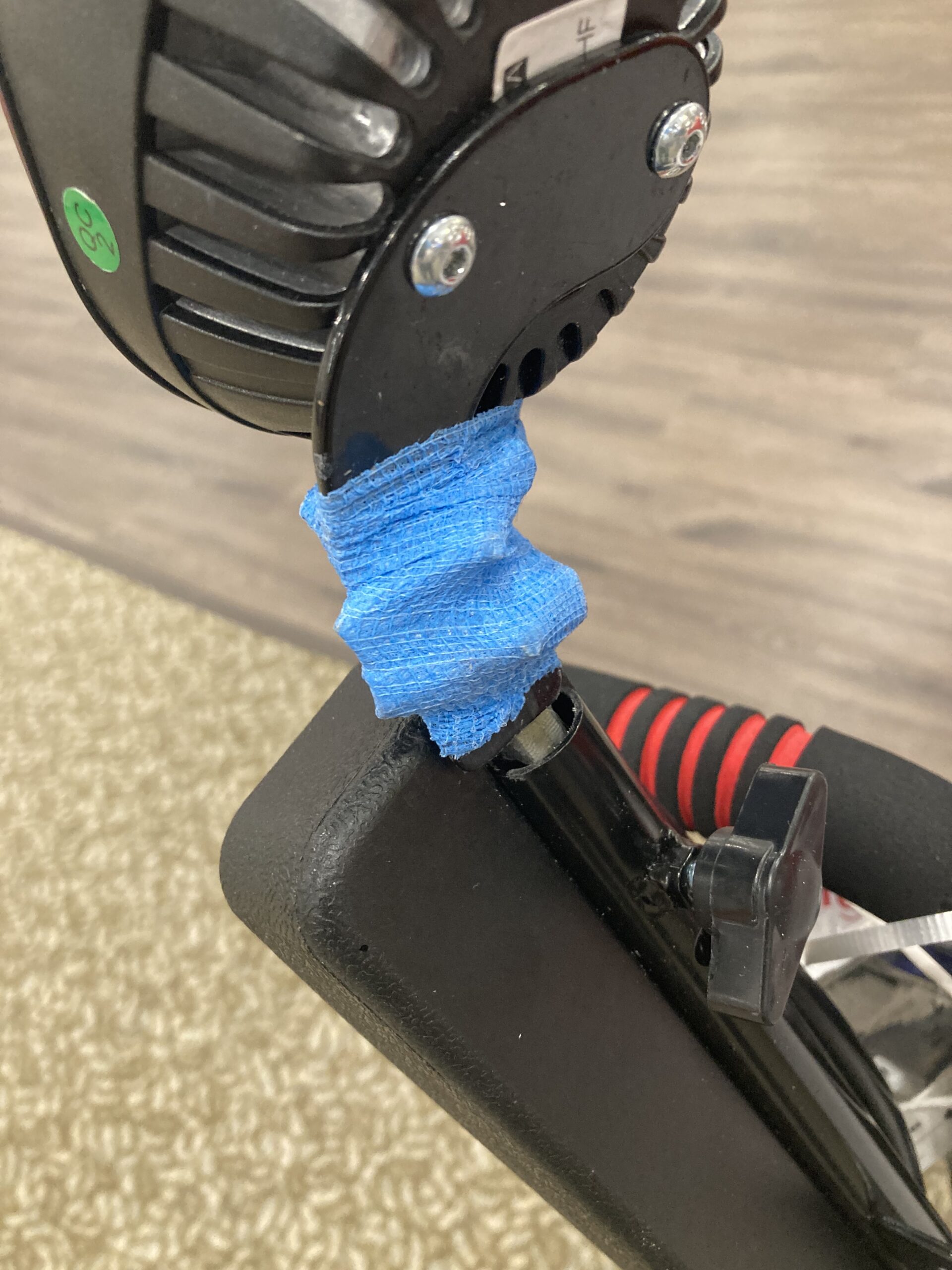 Blue athletic tape wrapped around bad hardware on an electric wheelchair.